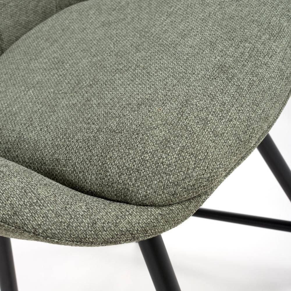 Close-up of green fabric dining chair seat with black metal legs