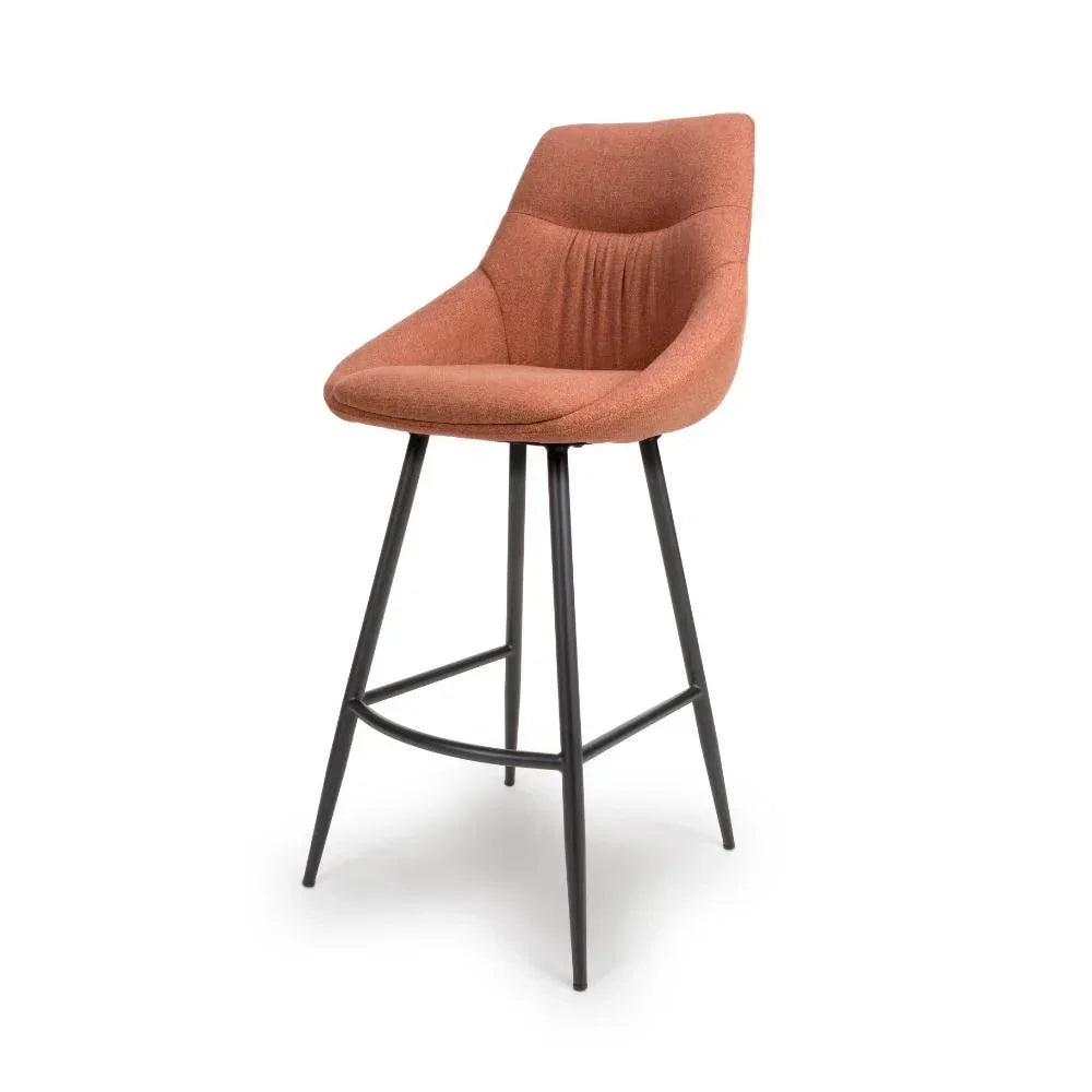Rust fabric bar stool with curved backrest and black metal legs, angled front view