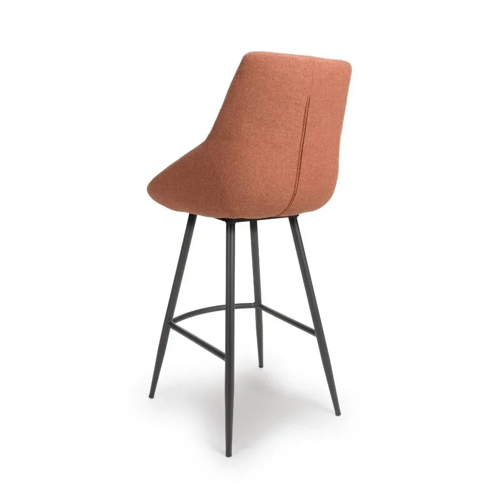 Rust fabric bar stool with high backrest and black metal legs, rear angled view