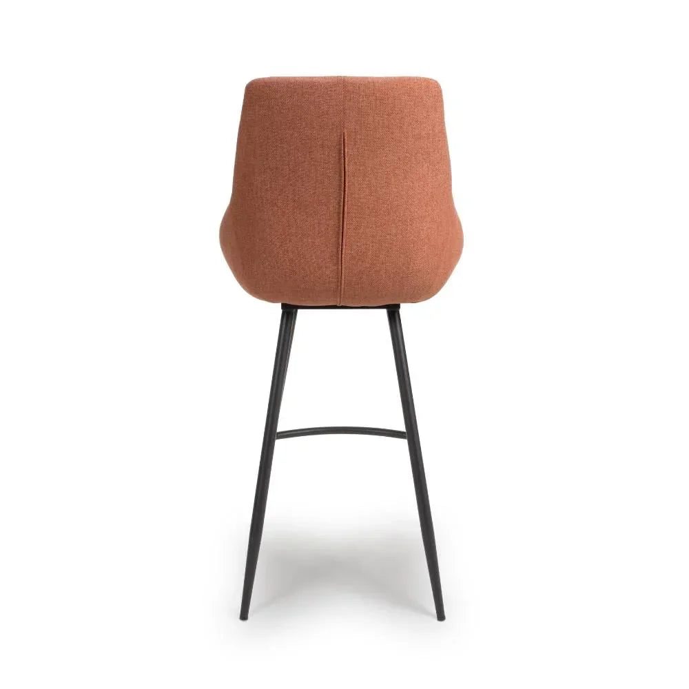 Burnt orange fabric bar stool with high back and black metal legs, rear view