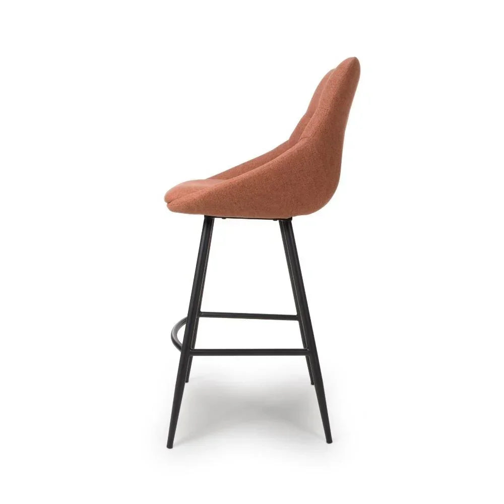 Brown upholstered bar stool with curved back and black metal legs, side profile view