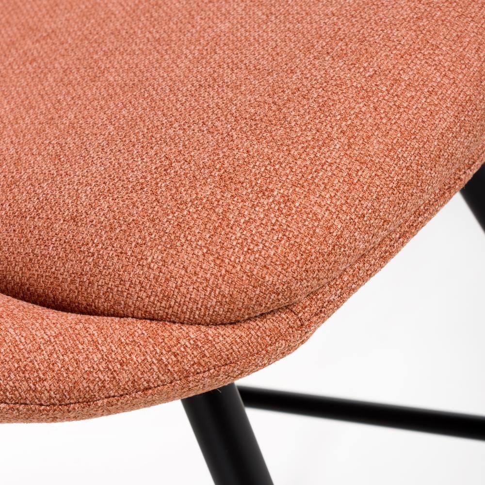 Closeup of orange fabric chair seat with black metal legs