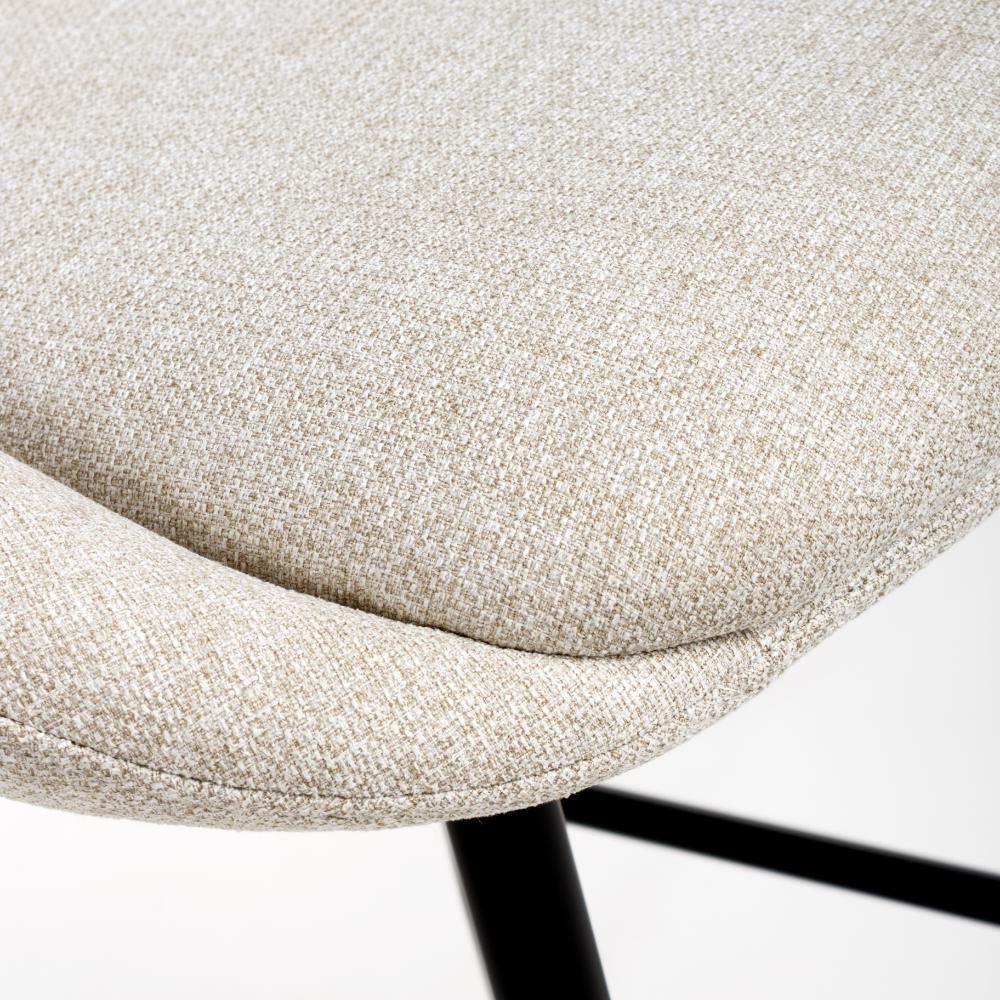 Close-up of beige fabric dining chair seat with black metal legs