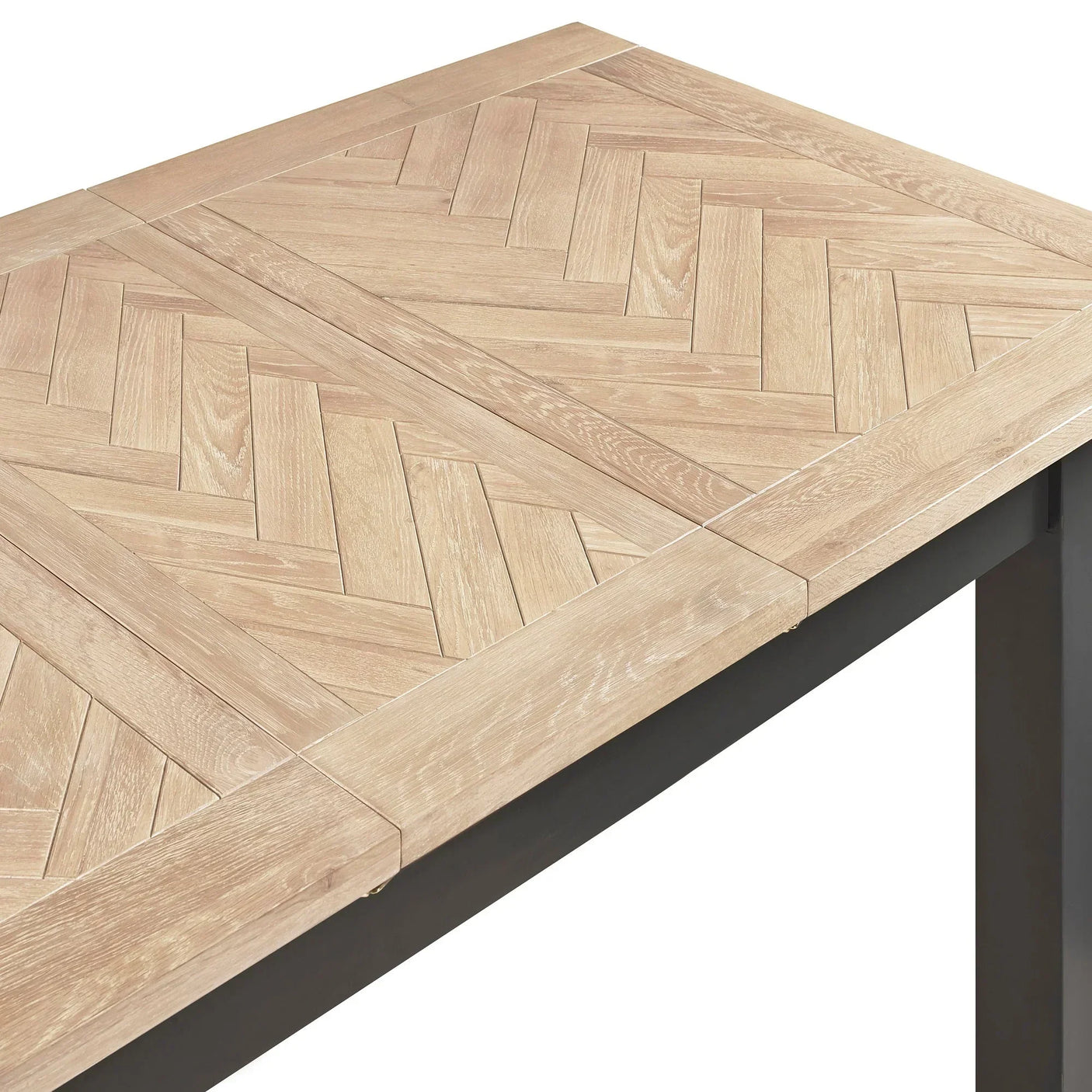 Bordeaux extending dining table with herringbone oak top and metal legs, close-up corner view
