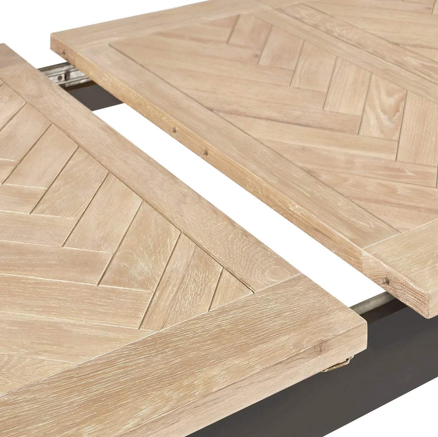 Close-up of light oak extending dining table top with chevron wood pattern detail