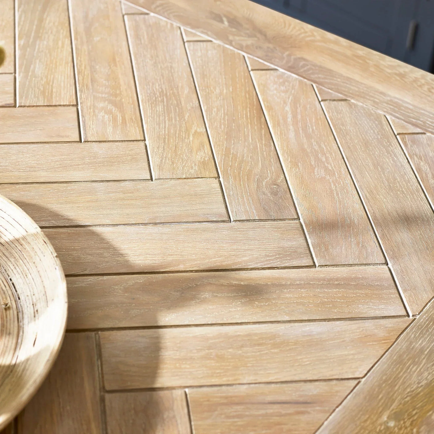 Bordeaux parquet wooden table top detail with herringbone pattern and light oak finish