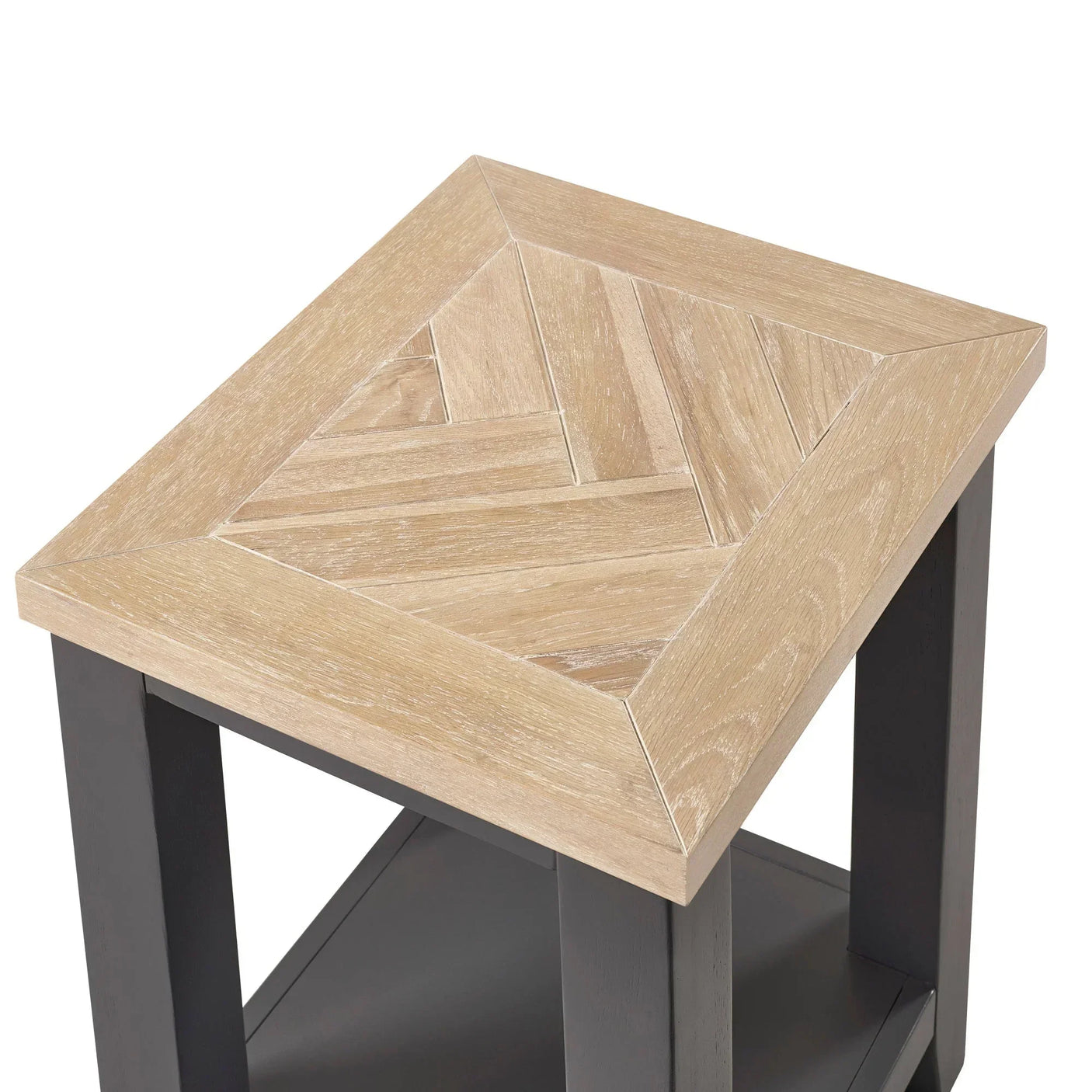 Square wood side table with light herringbone top and black legs, close corner view