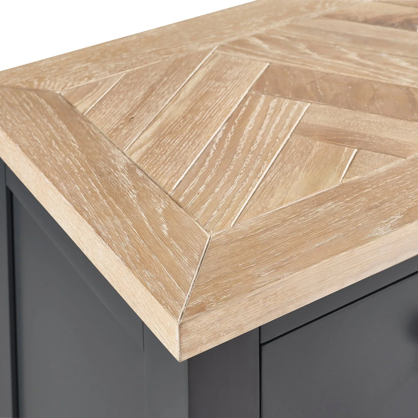 Closeup of oak sideboard with chevron patterned wood top and matte dark base