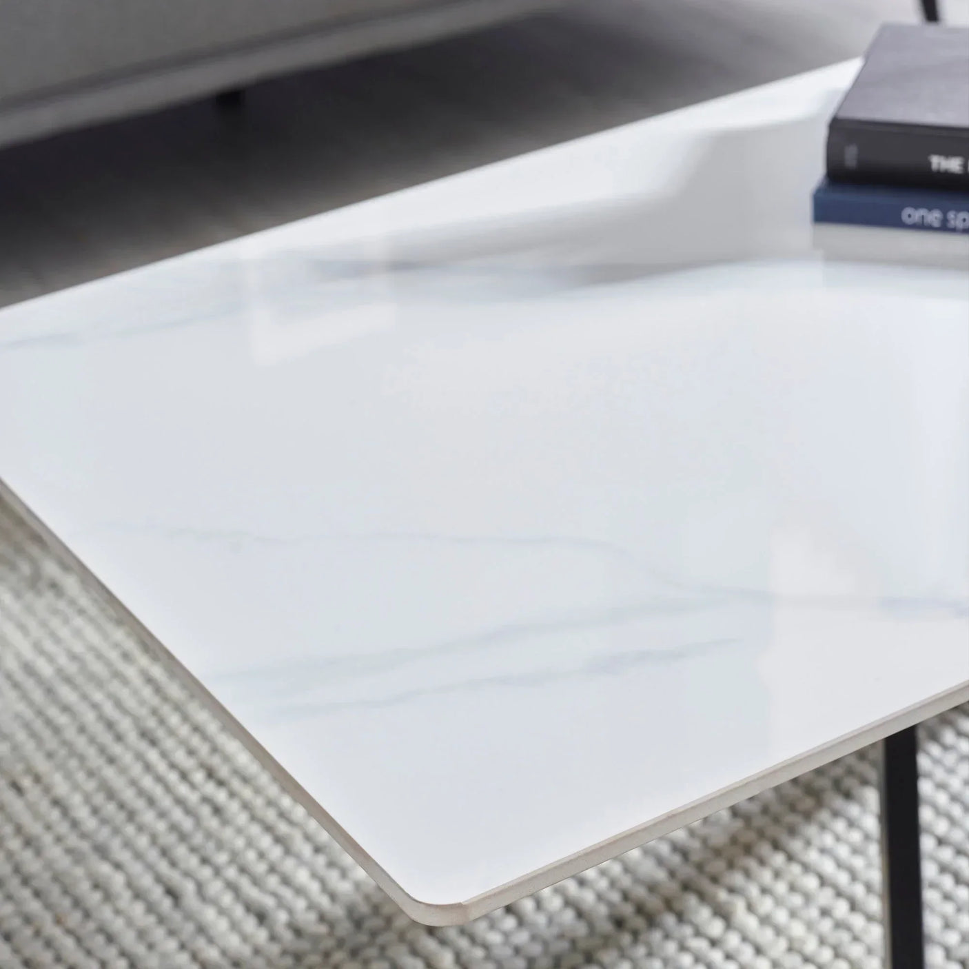 White marble coffee table top with subtle veining and smooth edges on woven rug