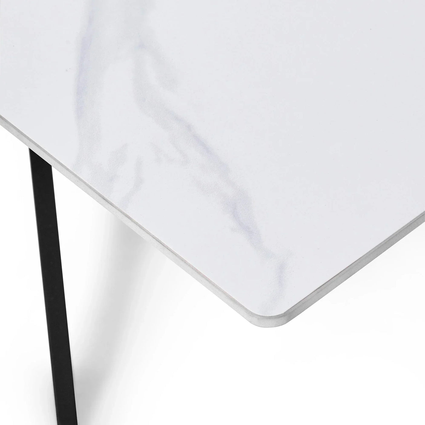 White marble coffee table corner with subtle veining and black metal leg detail