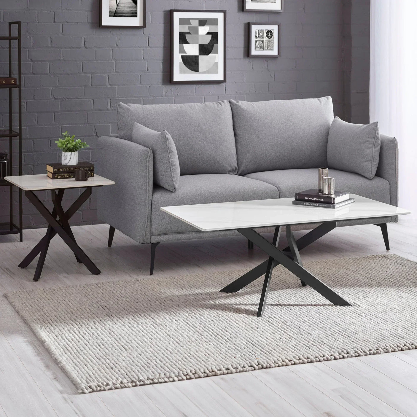 Grey fabric sofa with marble top coffee table and side table on light rug in modern living room