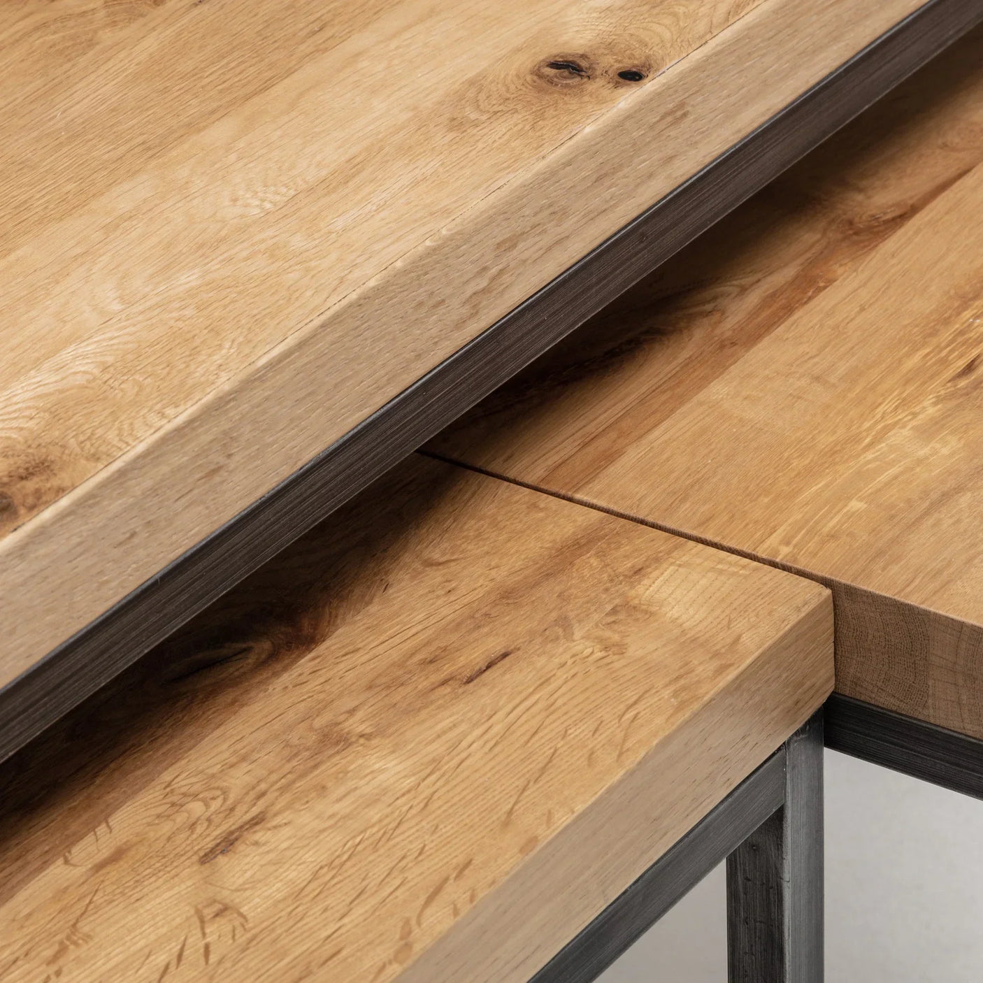 Close-up of Brooklyn nesting coffee tables with natural oak tops and metal legs
