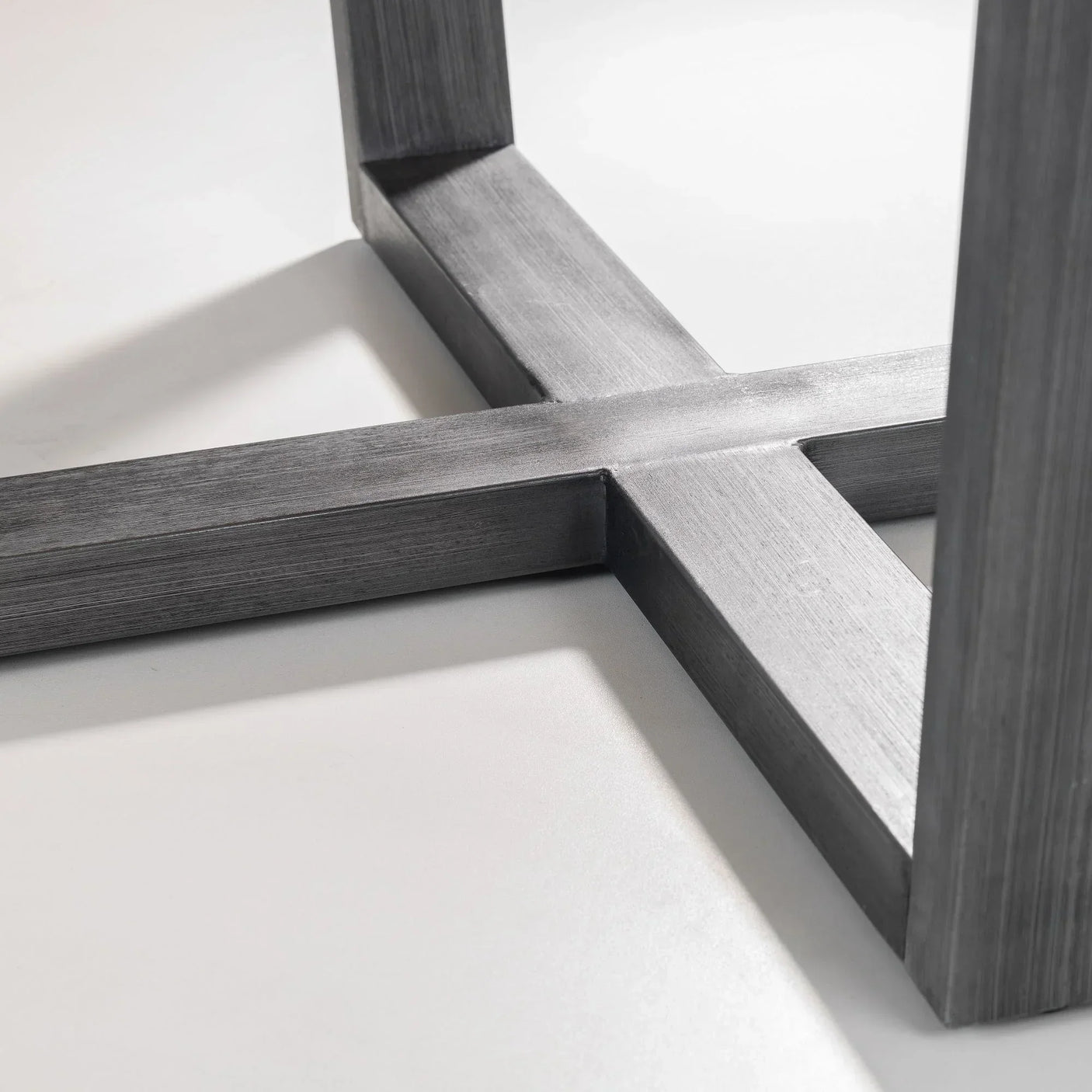 Close up of Brooklyn round table metal cross base in brushed finish