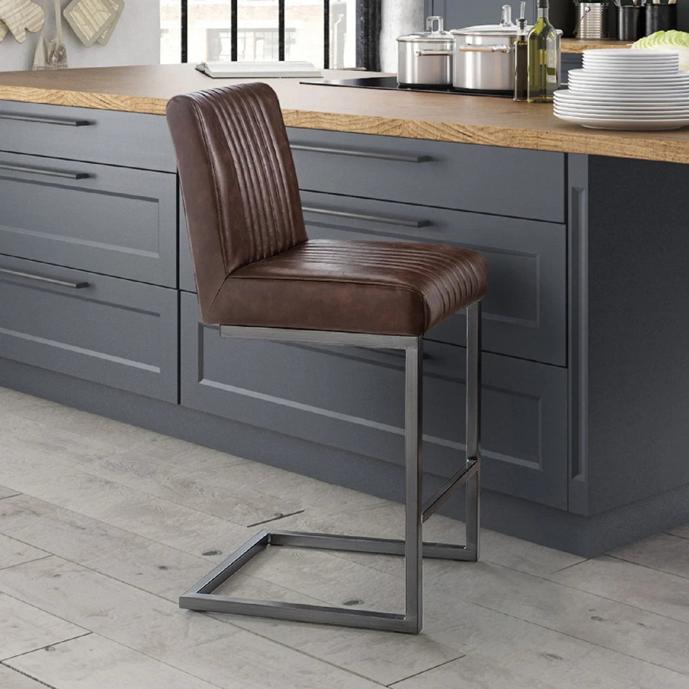 Brown leather bar stool with metal frame at modern kitchen island