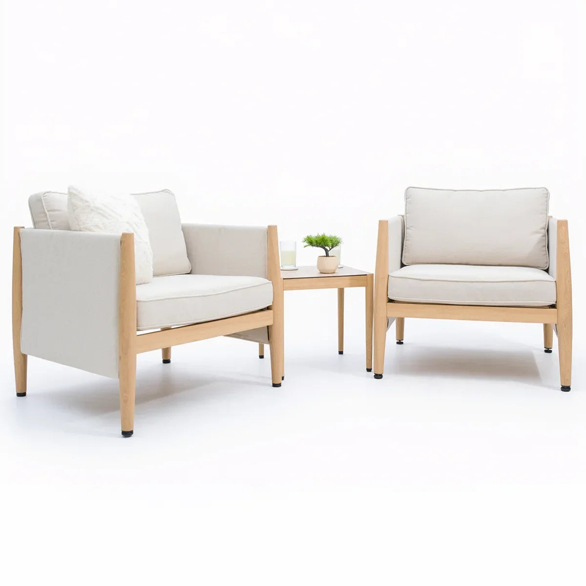 Cream cushioned wooden armchairs set with matching side table and decor plant