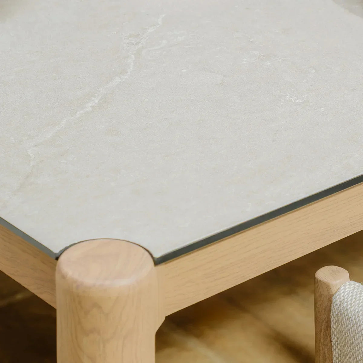 Corner view of light wood coffee table with cream stone top