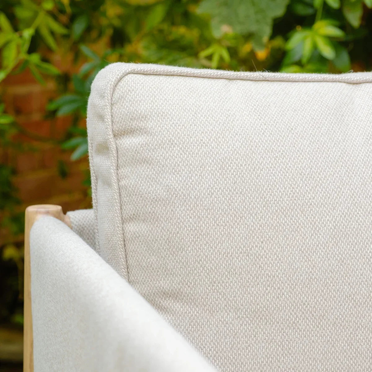 Close-up of beige outdoor sofa cushion with textured fabric and wood frame