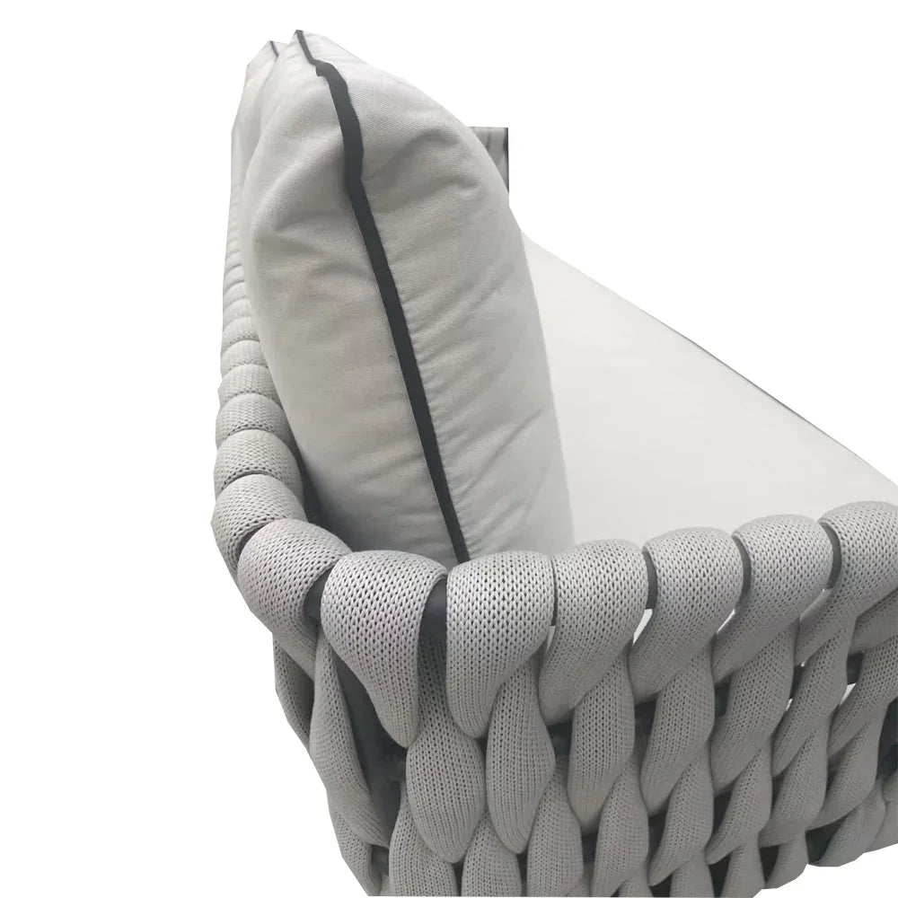 Close-up of grey woven sofa armrest with light cushion and fabric texture detail