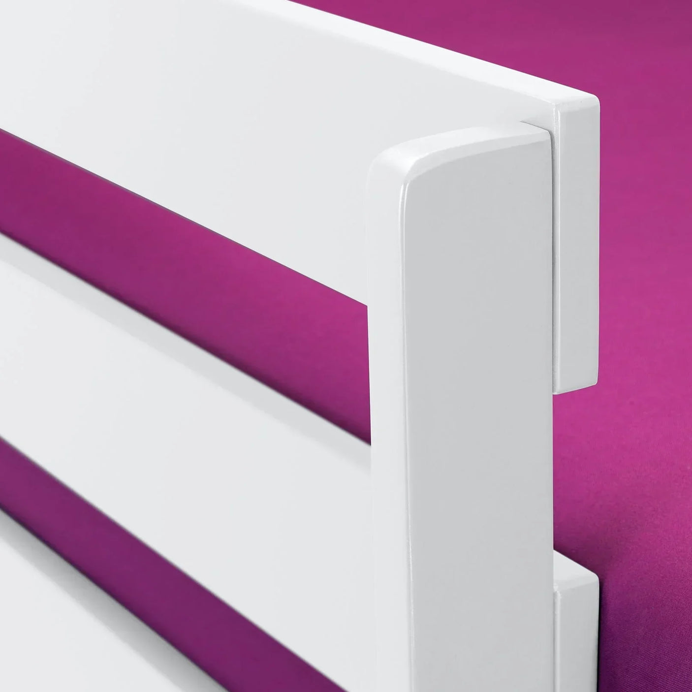 White bunk bed siderail detail with smooth finish against pink bedding