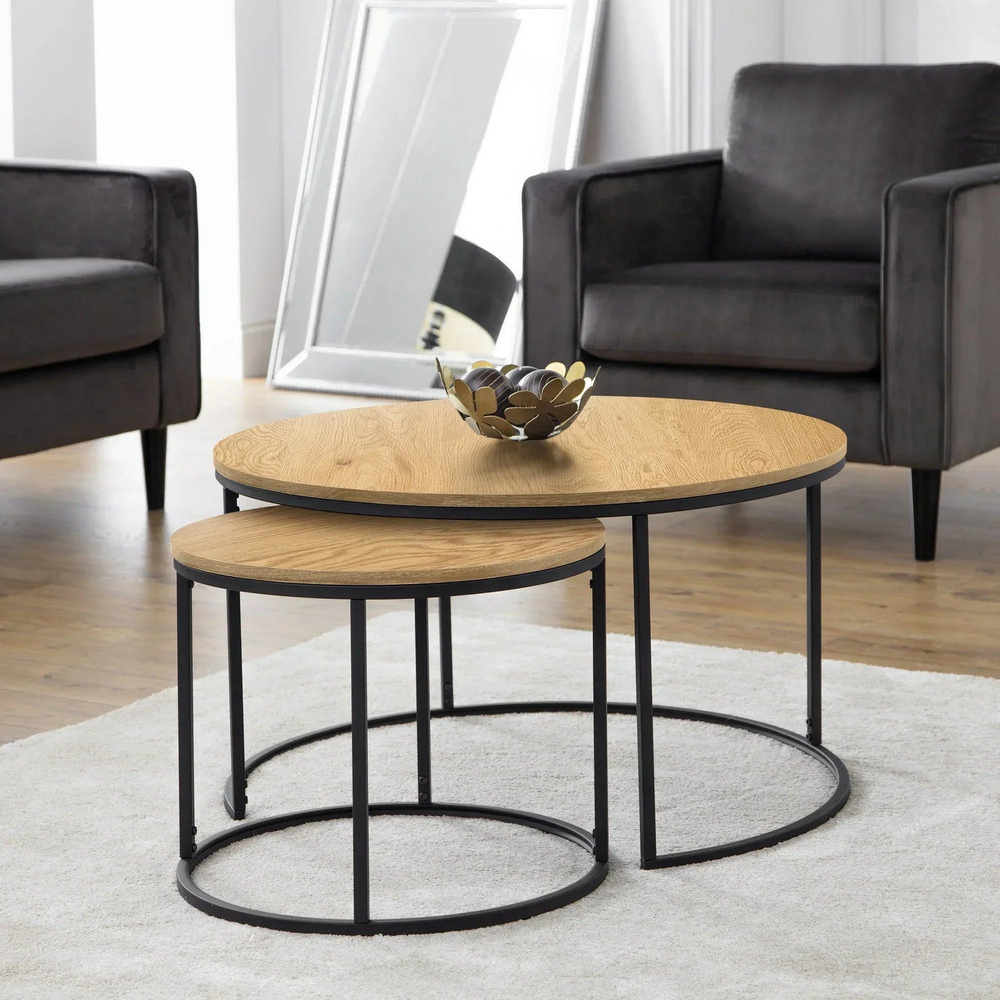 Oak nest of coffee tables with black metal frames in modern living room setting