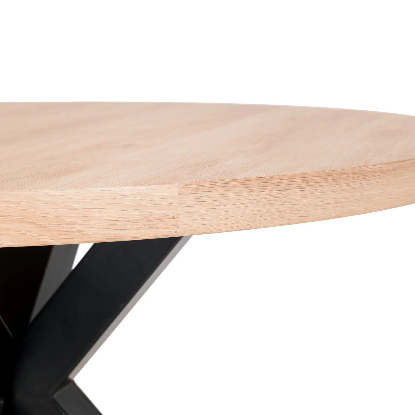 Closeup of round wooden dining table top with black metal leg and light oak finish