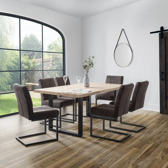 Rectangular dining table with black metal legs and six charcoal chairs in modern dining room
