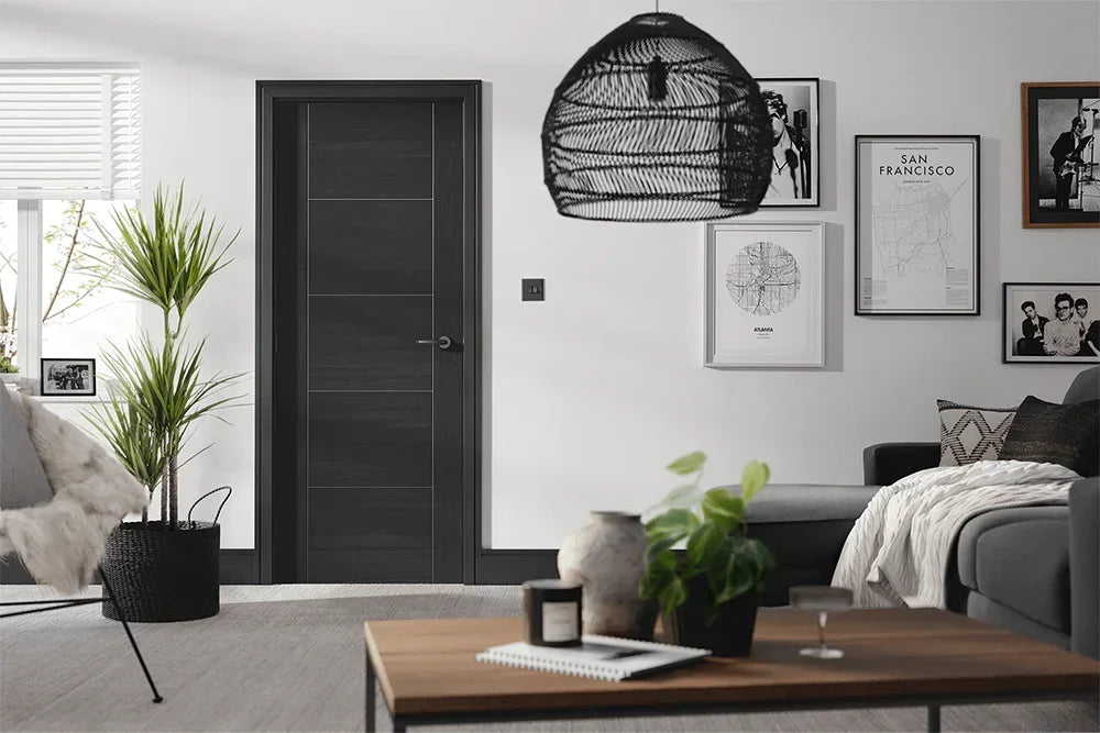 Black ash laminate interior door in modern living room with sofa, table and indoor plants