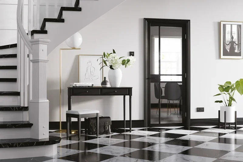 Black glazed internal door in modern hallway with monochrome checked floor and black console table