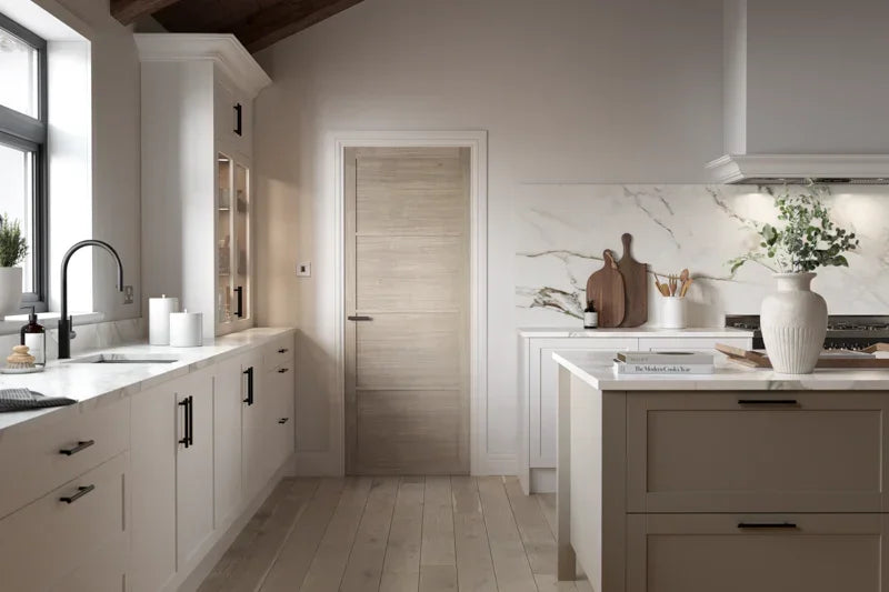 Blonde oak interior door in modern kitchen with marble worktops and light wood flooring