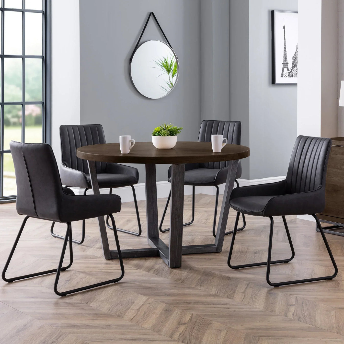 Dark oak round dining table with four black Soho dining chairs in modern room setting