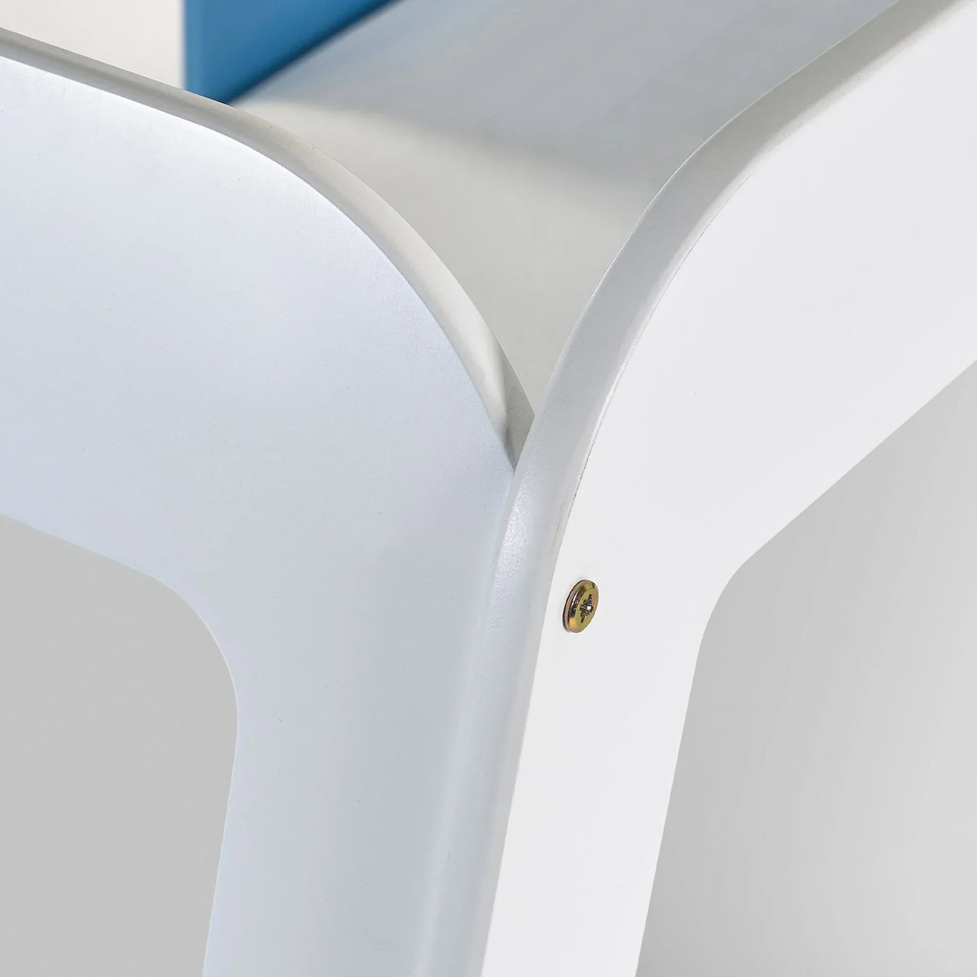 White campervan bed frame detail showing curved corner and visible screw