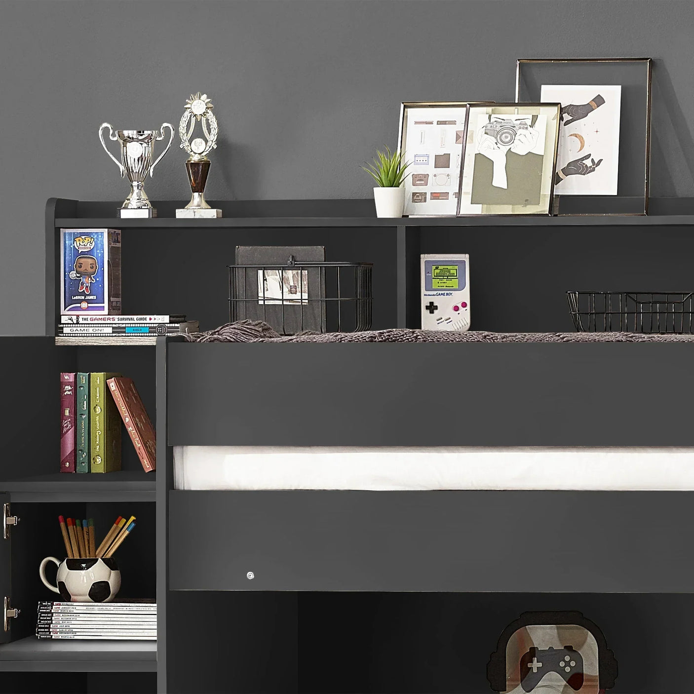 Anthracite staircase bunk bed with open shelving, books, trophies, and decor items