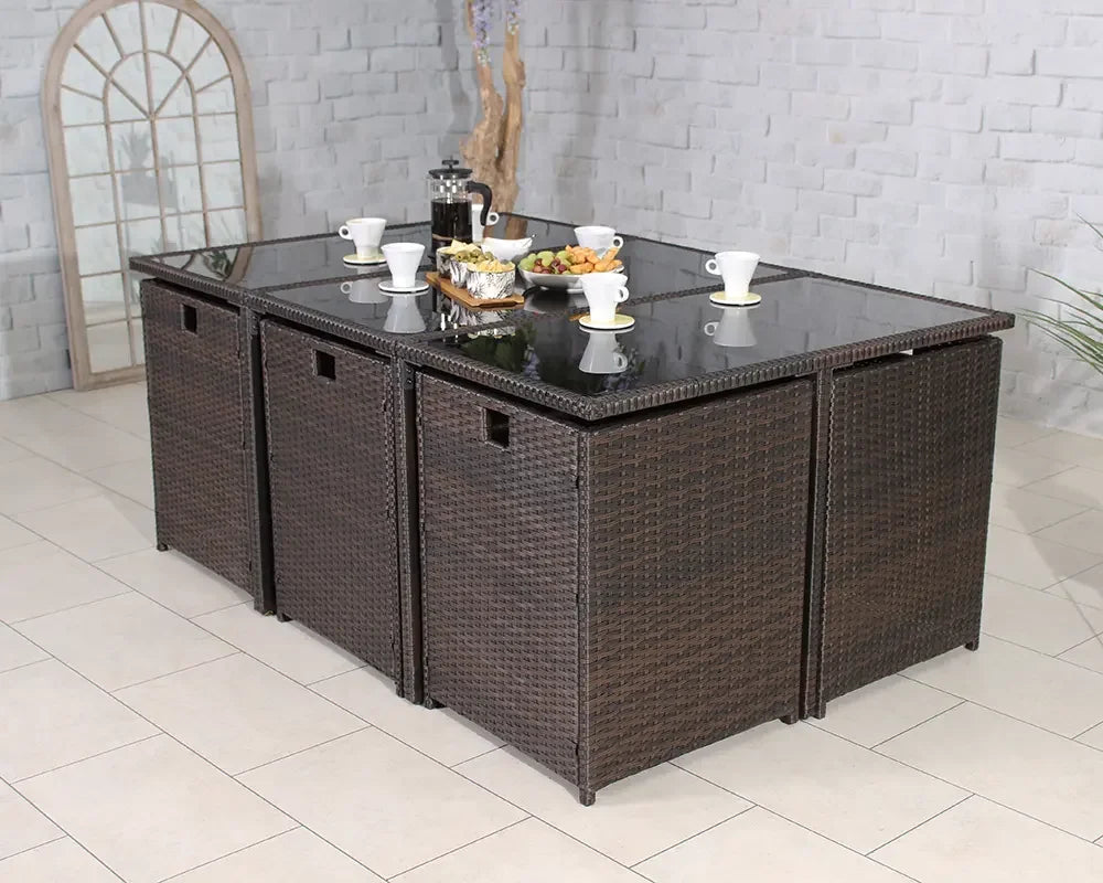 Brown rattan garden dining set with glass tabletop and coffee service in a tiled patio area