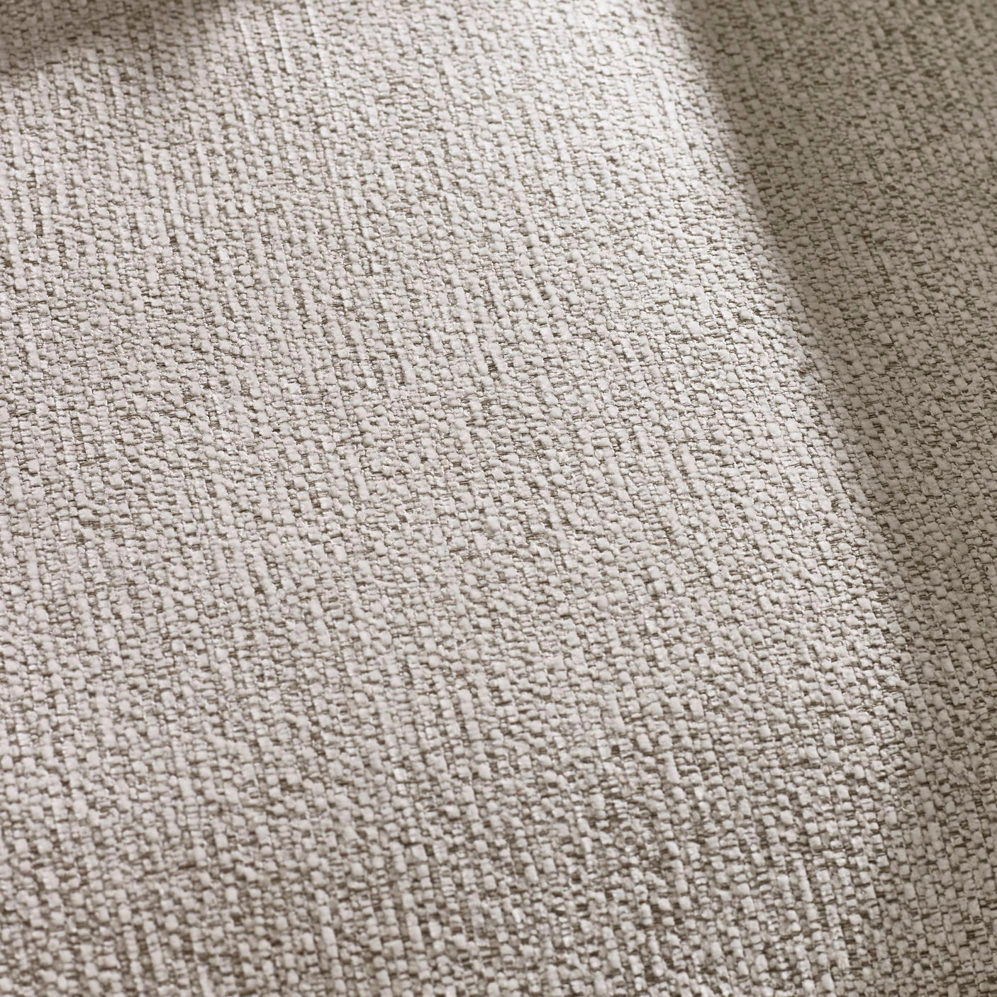 Close up of textured beige carpet fibers with subtle linear pattern