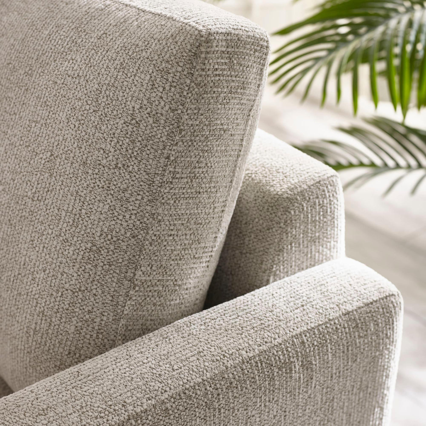 Close-up of textured beige sofa armrest and backrest in natural light