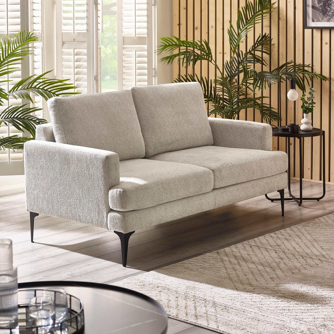 Light grey fabric sofa with black metal legs in a modern living room setting