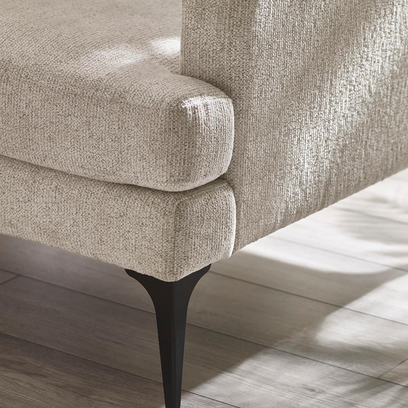 Beige fabric sofa corner with metal tapered leg on wood floor