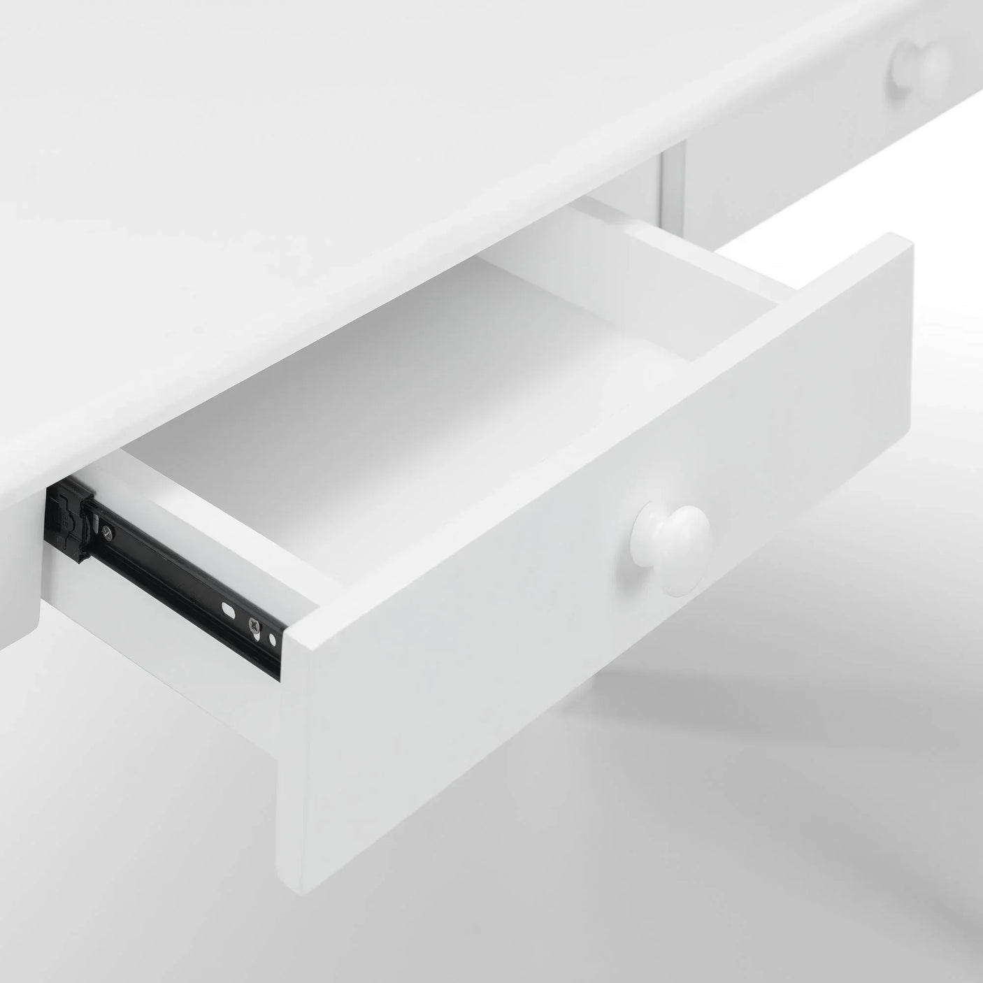 White desk with open drawer showing interior and round handle detail