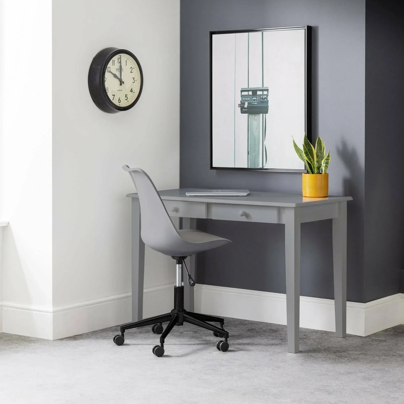 Grey home office desk with two drawers, grey swivel chair, plant and wall clock