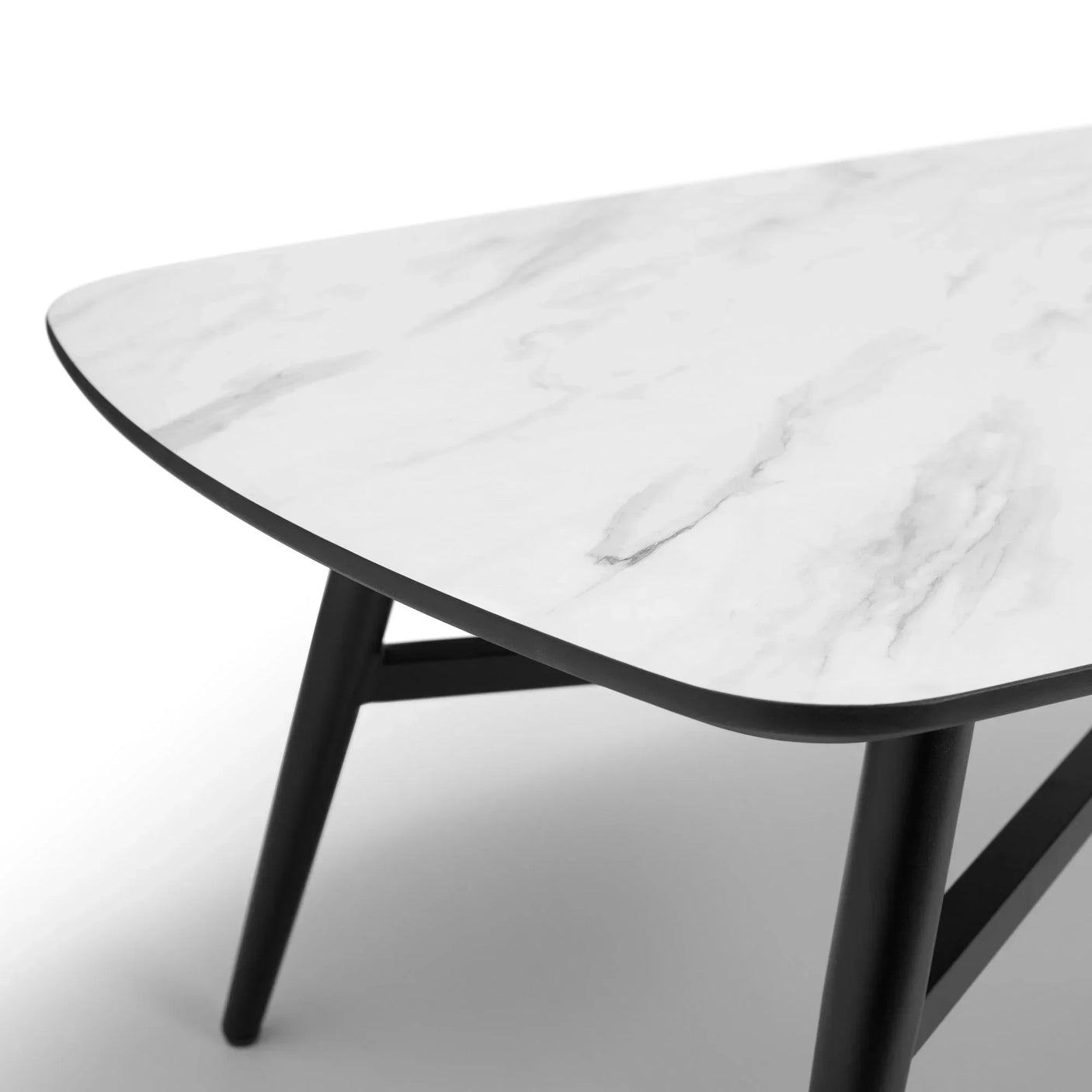Rectangular marble effect dining table with black angled legs, close-up corner view