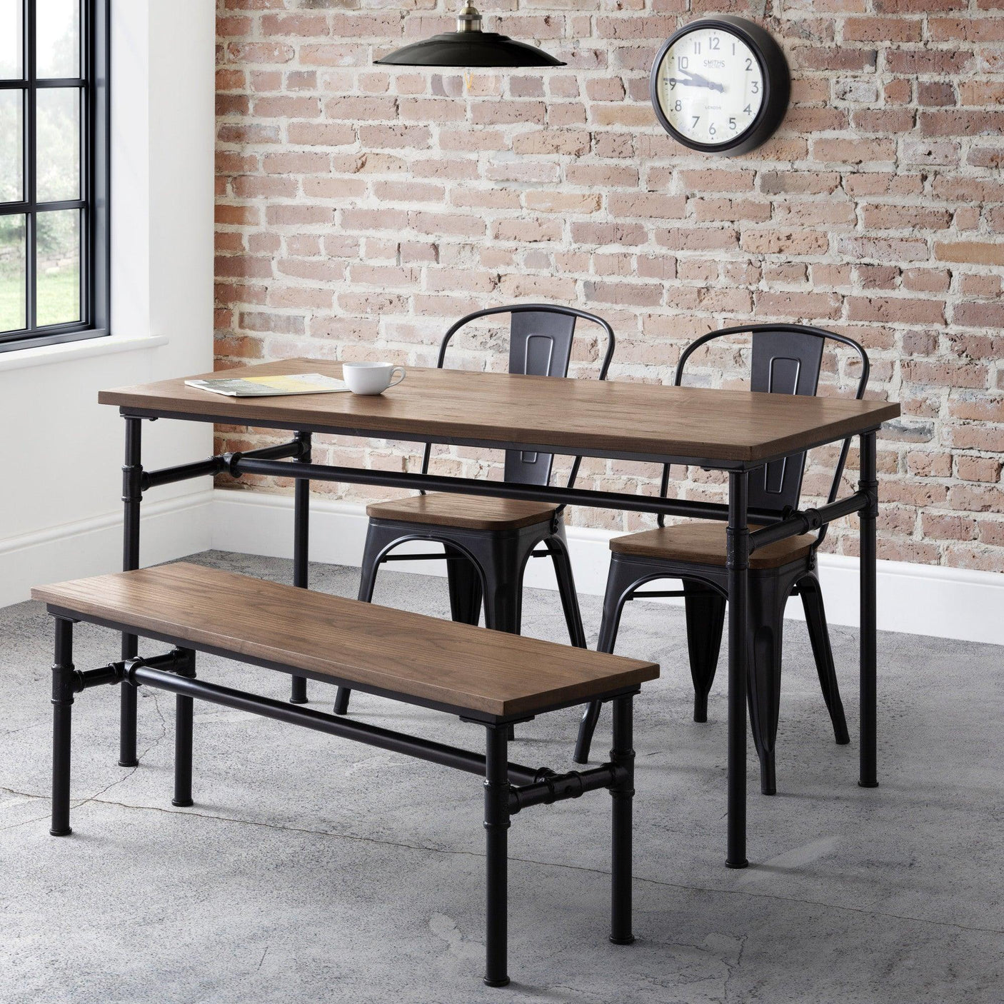 Industrial dining table set with wooden top, metal chairs and matching bench in loft kitchen