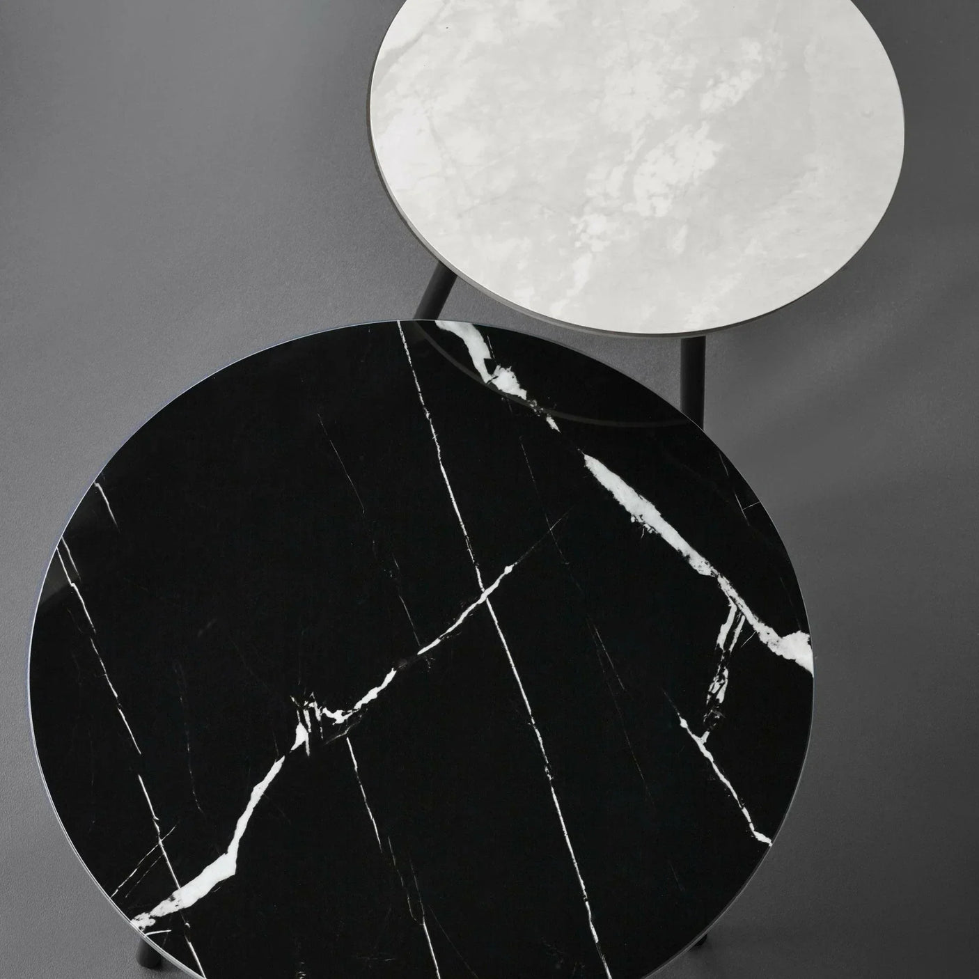 Round black and white marble nesting coffee tables with metal legs, top view