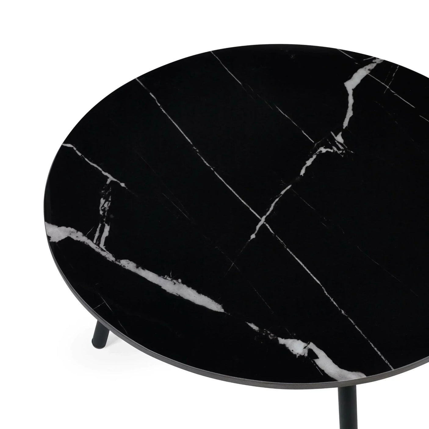 Round black marble coffee table with white veining and slim metal legs