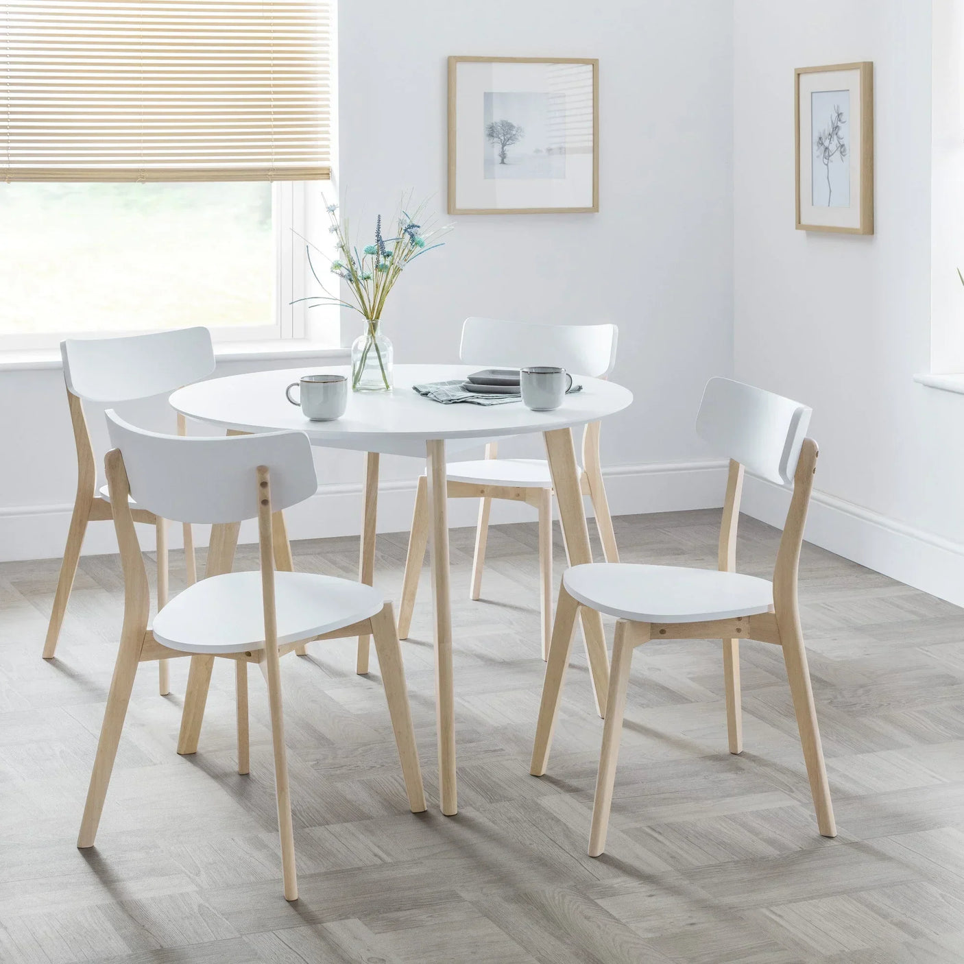 White round dining table with four white and wood chairs in modern dining room