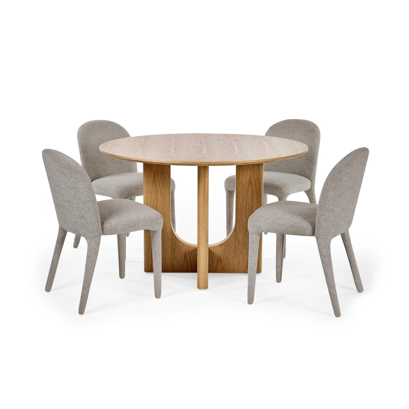 Round oak dining table with four grey upholstered chairs on white background