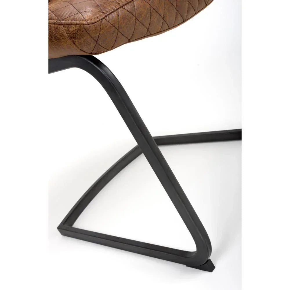 Closeup of brown leather dining chair with black metal cantilever leg
