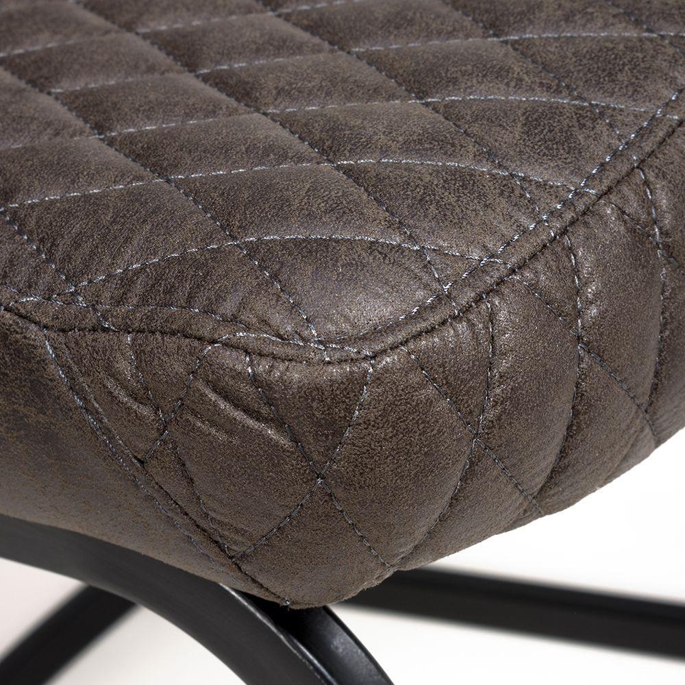 Closeup of brown faux leather dining chair seat with quilted stitching and black metal frame