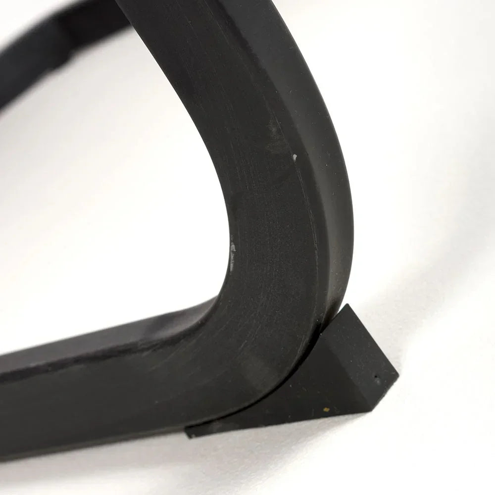 Close-up of black metal furniture leg with curved design on white background