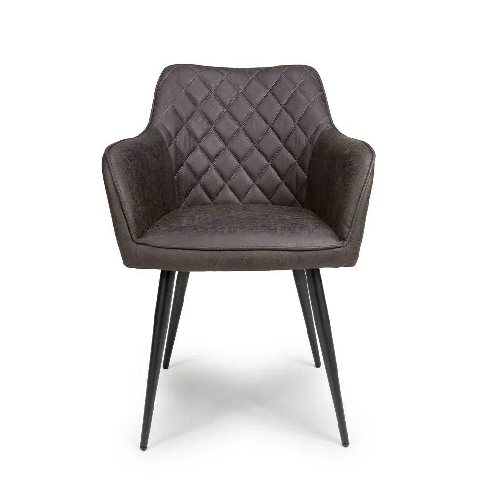 Grey velvet dining chair with diamond-stitched backrest and black tapered metal legs, front view