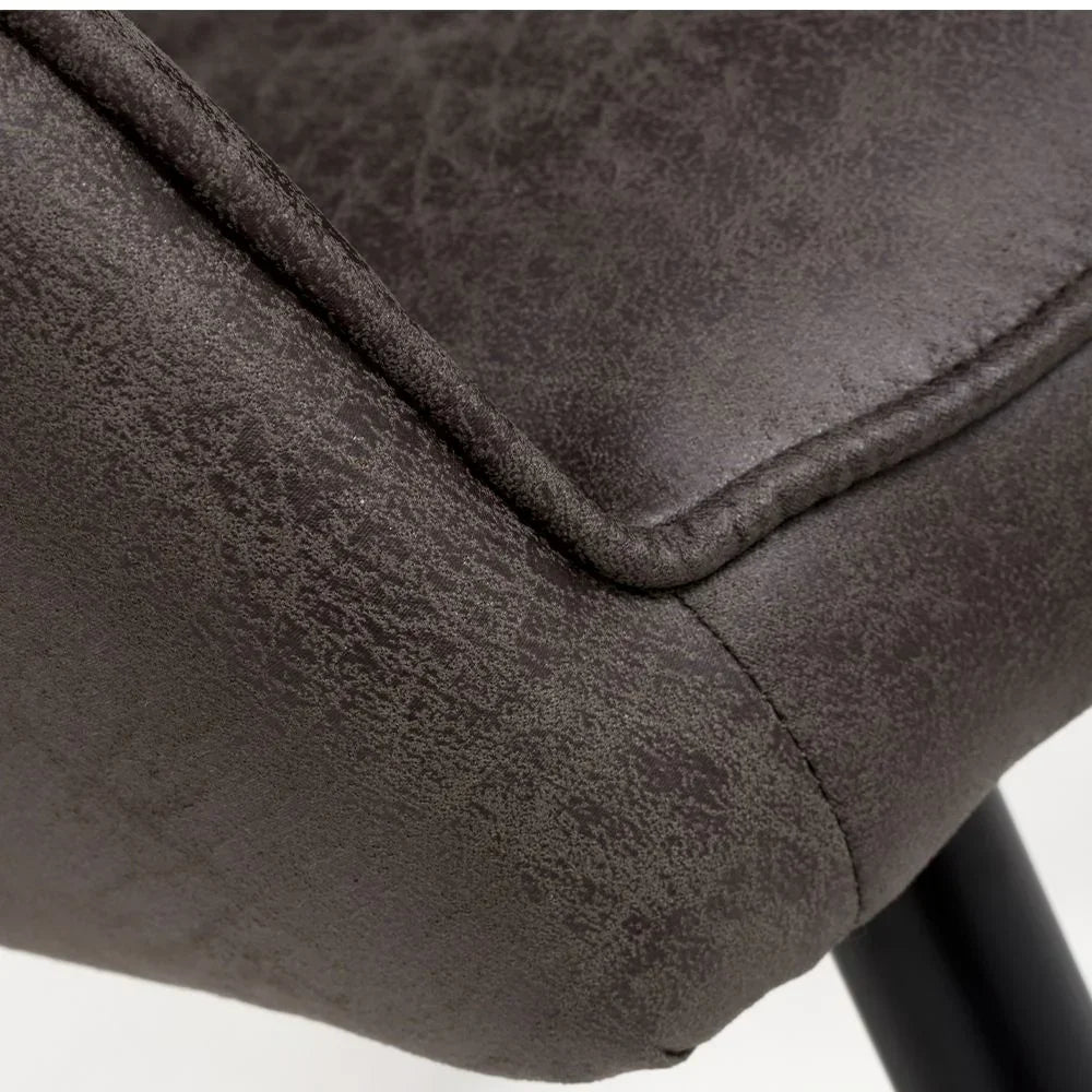 Close-up of textured grey dining chair seat with stitching and black metal leg